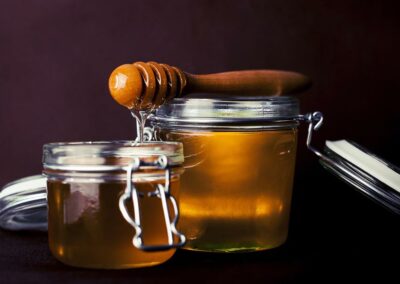 Zwei Gläser Honig mit einem Honiglöffel